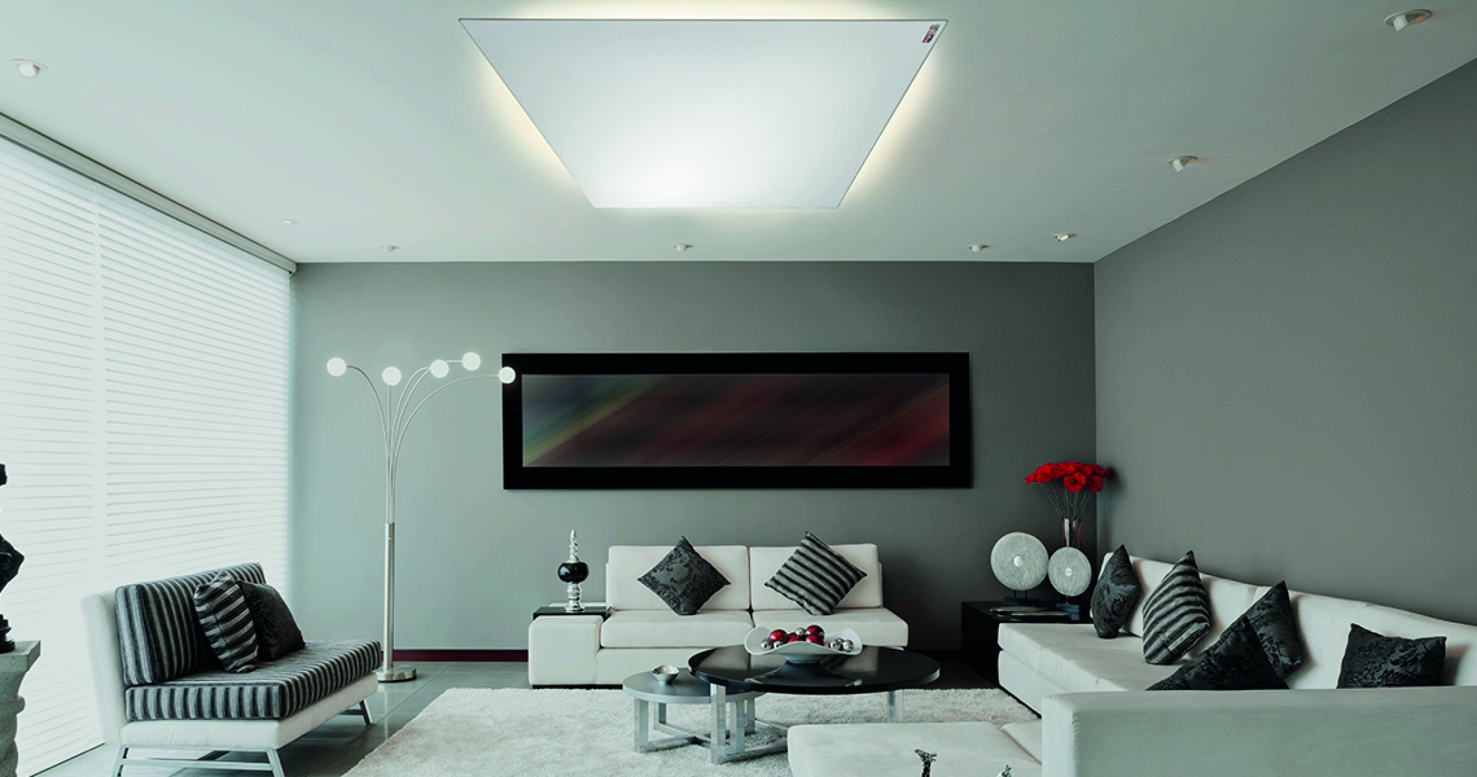 Infrarot-Heizungen: ein Wohnzimmer mit einer modernen Infrarot-Heizung über der Sitzecke. Eine Heizung an der Wand kombiniert mit einem LED-Rahmen ...