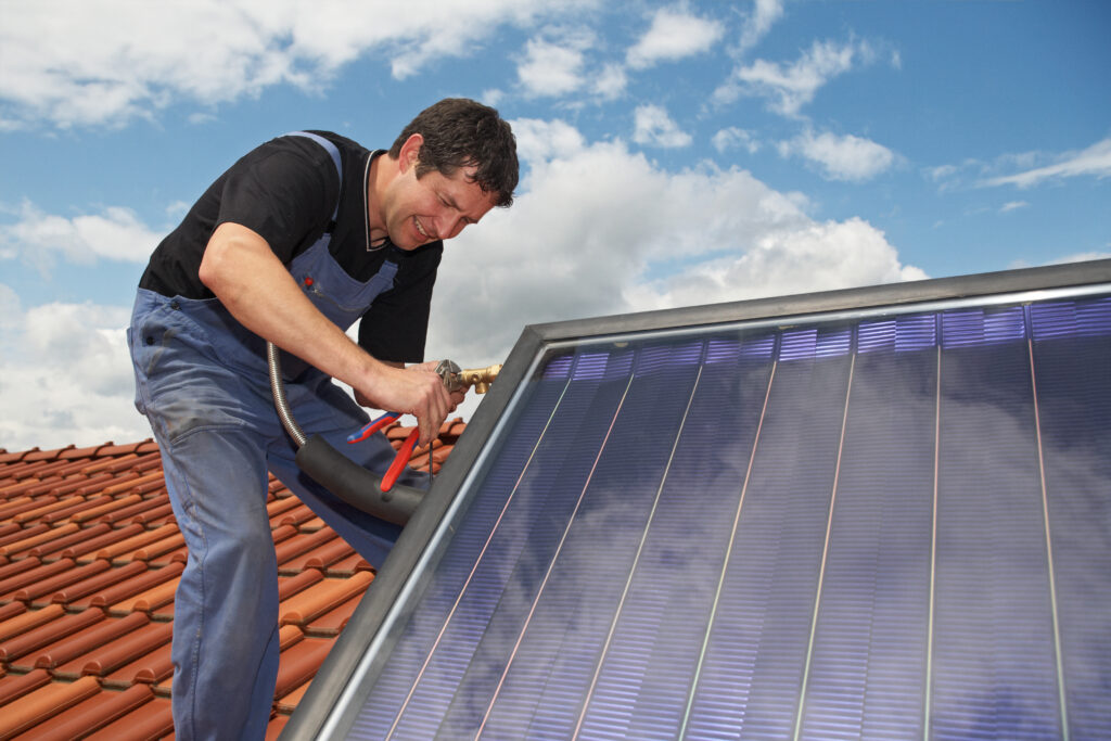 Fachmann mit Solarthermie auf dem Dach: Checkliste für eine effiziente Solarthermie