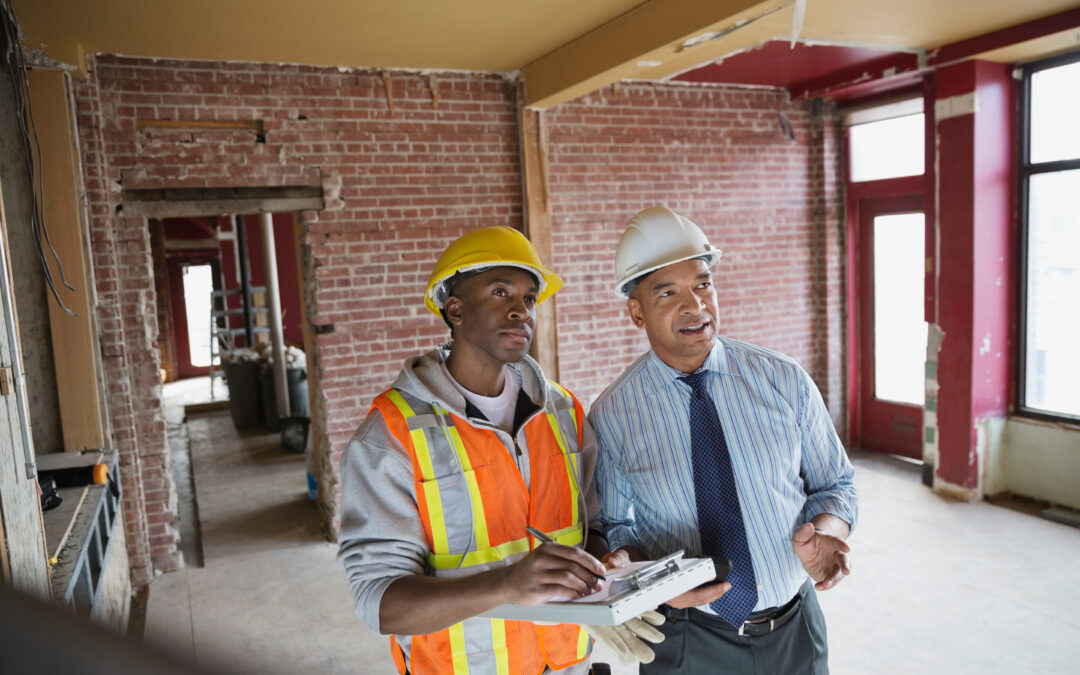 Energieeffizienz beim Bauen: Ein Bauarbeiter und Mann schauen sich das Haus an
