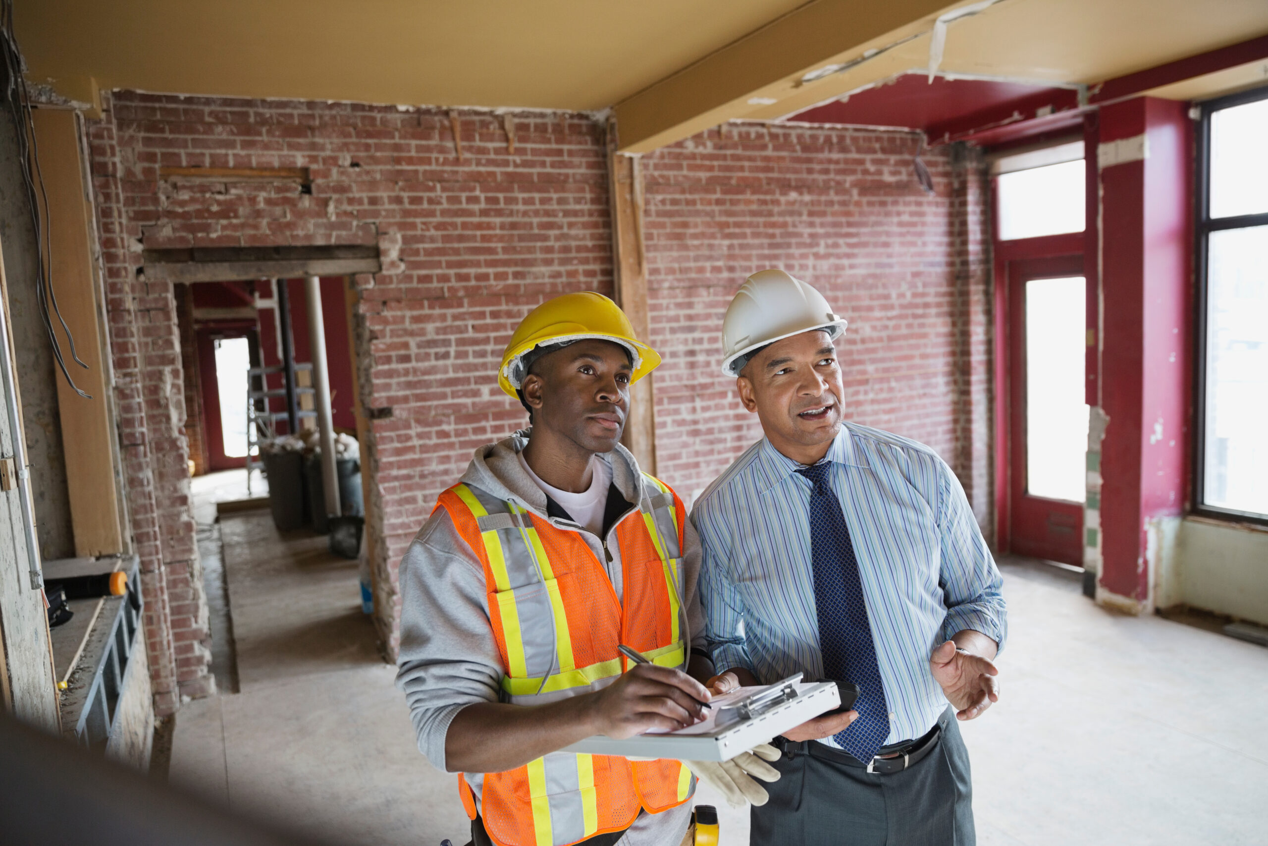 Energieeffizienz beim Bauen: Ein Bauarbeiter und Mann schauen sich das Haus an