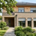 Wohnung kühl halten: ein Einfamilienhaus mit halb heruntergelassenen Außenrollläden hält die Sommerhitze draußen